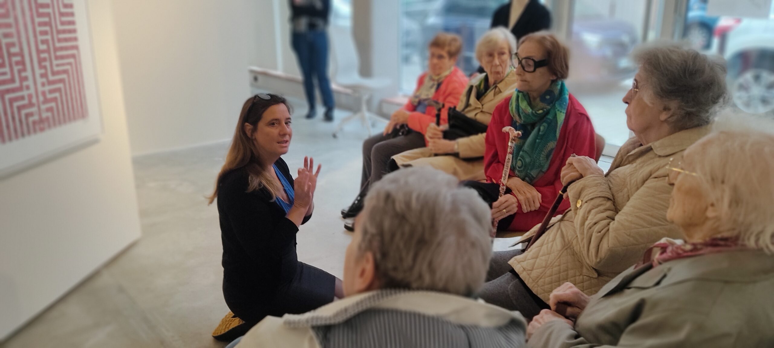 Julie assise par terre devant le public dans la galerie d'art Sabrina Lucas