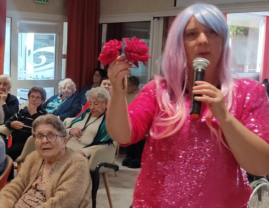 Julie avec une perruque rose lors de sa conférence adaptée autour de la chanson d'Edith Piaf, La Vie en rose